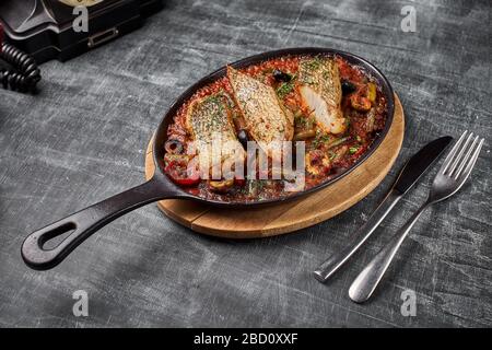Perch stufato in salsa di pomodoro, servire il cibo in stile provenzale, in una padella. Vista dall'alto, copia spazio. Foto Stock