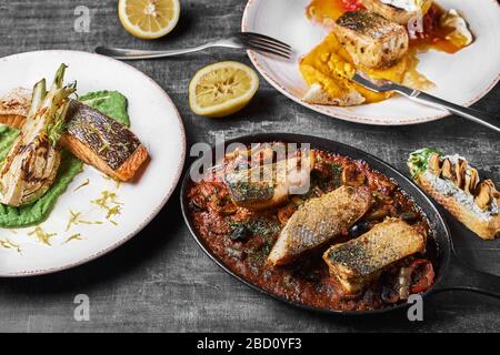 Piatto di pesce di tre portate Pike Perch, bistecca di salmone, persico stufato. Menu dietetico. Menu di pesce. Frutti di mare. Concetto di cibo sano. Foto Stock