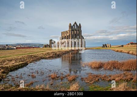 Resti di un'antica abbazia gotica inglese rovine con riflessione in acqua lago Foto Stock