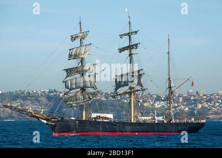 Sydney Australia, Schooner al largo della costa di Sydney con suburbia sullo sfondo Foto Stock