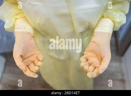 Dresda, Germania. 3 aprile 2020. ILLUSTRAZIONE - UN assistente dentale sta per trattare un paziente corona in una pratica dentale con camici antivirali e guanti di gomma in uno spogliatoio. (Posed scene) Credit: Robert Michael/dpa-Zentralbild/dpa/Alamy Live News Foto Stock