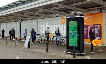 Glasgow, Scozia, Regno Unito, 6 aprile 2020: Coronavirus vide strade deserte e strade vuote, come DrumChapel sainsburys vide una coda di trolley a distanza sociale e pubblicità apt . Gerard Ferry/Alamy Live News Foto Stock