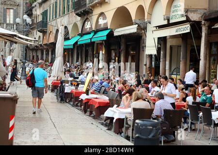 Italia, Verona - 16 giugno 2019: Piazza Erbe di Verona, folla di turisti in un ristorante di strada Foto Stock