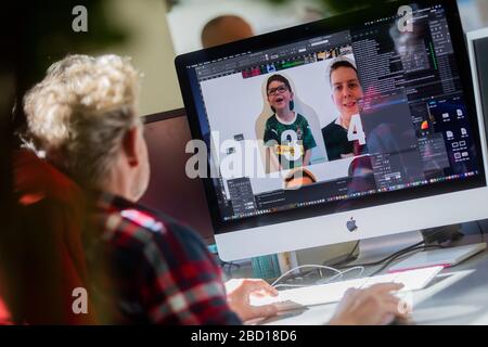 06 aprile 2020, Renania settentrionale-Vestfalia, Mönchengladbach: Andreas Hofmann, grafico, lavora sui primi "compagni di cartone" - appassionati di Borussia Mönchengladbach - sul suo computer in un negozio di stampa. Gli appassionati di Borussia Mönchengladbach vogliono contribuire ad un'atmosfera migliore alle possibili partite di fantasmi nella lega di calcio tedesca. Per risparmiare agli spettatori della TV e ai professionisti la visione dei sedili vuoti dello stadio, i personaggi di cartone con la somiglianza dei tifosi devono essere allestiti a grandezza naturale - se lo si desidera, dove anche gli spettatori si alzano o si siedono durante i normali giochi. Foto: Rolf Vennen Foto Stock