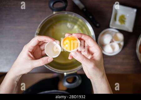 donna tuorli d'uovo separati e bianchi per la cucina e la cottura Foto Stock