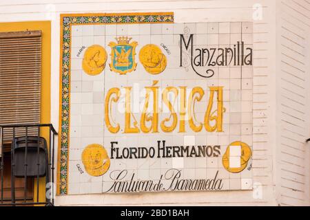 Una vecchia pubblicità murale piastrellata per il produttore di vino Florido Hermanos su un muro a Siviglia Spagna Foto Stock