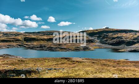 Norvegia alta montagna lago sul paesaggio giorno di sole. Viaggio natura selvaggia, cielo blu, colori brillanti. Escursioni scandinave scenario Foto Stock