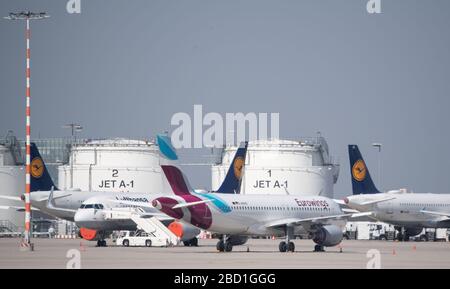 Stoccarda, Germania. 06th Apr, 2020. Gli aeromobili delle compagnie aeree Lufthansa ed Eurowings si trovano di fronte ai serbatoi di carburante sul piazzale dell'aeroporto. L'aeroporto di Stoccarda è chiuso a causa del rinnovo della pista. Secondo l'aeroporto, non ci saranno voli fino al 22 aprile. La ristrutturazione della pista era comunque prevista per quest'anno, ma avrebbe dovuto iniziare un po' più tardi. Credit: Marijan Murat/dpa/Alamy Live News Foto Stock