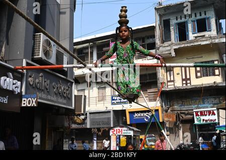 Giovane ragazza che si esibisce su una stretta eretta in una strada trafficata per guadagnare soldi, vecchio Ahmedabad, Gujarat, India, Asia Foto Stock