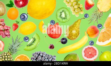 Foto creativa di molti frutti tropicali esotici e luminosi su uno sfondo verde estivo. Vista dall'alto. Luminoso modello di frutta estiva. Foto Stock