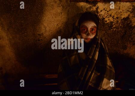 Zapotec ragazza con candela tra tombe adornate con marigolds, Atzompa, Oaxaca, Messico, Nord America Foto Stock
