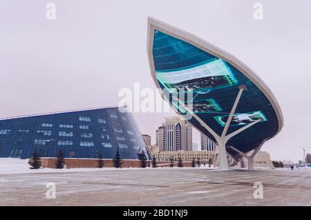 Nur-Sultan, Kazakhstan, 03 gennaio 2020: Vista dal basso sul Monumento Muro della Pace e parte dell'università nazionale d'arte con paesaggio urbano sul retro Foto Stock