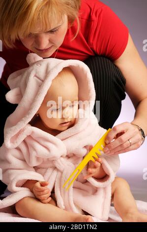 Il ritratto di piccola bella ragazza in accappatoio rosa su sfondo chiaro Foto Stock