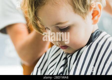 Un ragazzino in un parrucchiere Foto Stock