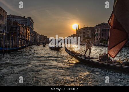 Gondolieri in silhouette governare le gondole sul Canal Grande al tramonto, Venezia, Italia Foto Stock