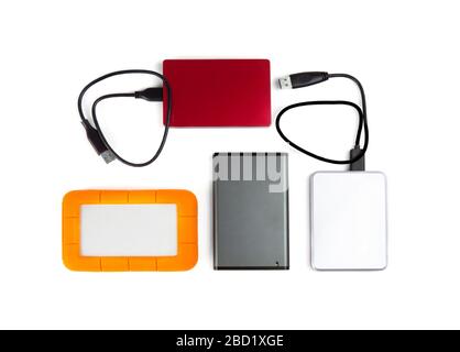 Quattro unità disco rigido portatili di colori e dimensioni diverse isolate sulla vista dall'alto bianca. Foto Stock