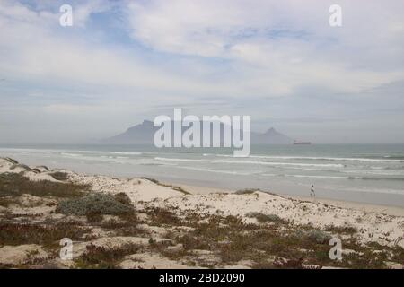 Vista sulla spiaggia, sull'Oceano Atlantico e sul Table Mountain, con il tempo nebbia. Città del Capo, Sudafrica, Africa. Foto Stock