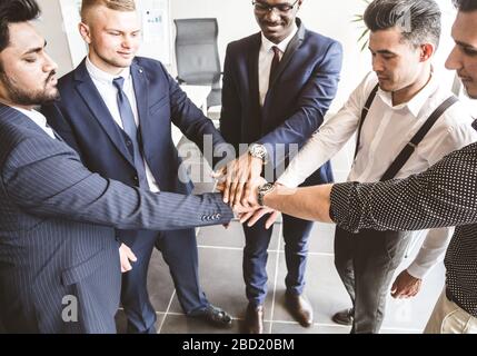 Un team di giovani imprenditori che lavorano e comunicano insieme in un ufficio. Uomini d'affari aziendali e manager in una riunione. Stretta di mano Foto Stock