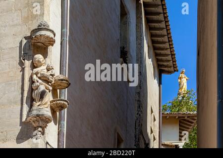 Statua della Madonna con il bambino in un angolo di strada, con la statua gigante dorata della Cattedrale di Avignone sullo sfondo, Provenza Foto Stock