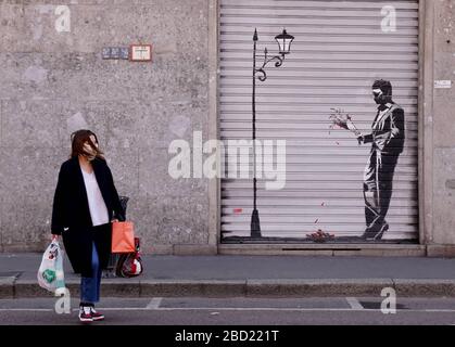 Milano, Italia. 06 aprile 2020. Emergenza coronavirus con maschere di fronte alle persiane ribassate dei negozi con disegni di Banksy (Duilio Piaggesi/Fotogramma, Milano - 2020-04-06) p.s. la foto e' utilizzabile nel rispetto del contesto in cui e' stata vista, e senza intenzione diffamatorio del presente delle persone rapate Credit: Independent Photo Agency Srl/Alamy Live News Foto Stock