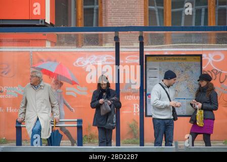 In attesa di un tram ad Amsterdam nei Paesi Bassi Foto Stock