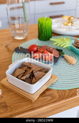 Composizione di cracker sani con pomodori e salsiccia. Foto Stock