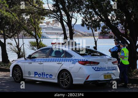 Sydney, Australia. 6 Aprile 2020. Gli agenti di polizia guardano la nave da crociera Ruby Princess ormeggiata a Port Kembla a Wollongong, Australia, 6 aprile 2020. Le autorità australiane hanno avviato un'indagine penale domenica sulla nave da crociera infetta da COVID-19, che è stata autorizzata ad attraccare a Sydney prima di liberare migliaia di passeggeri direttamente nella comunità. Credit: Zhu Hongye/Xinhua/Alamy Live News Foto Stock