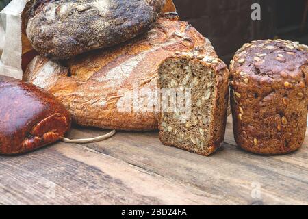 assortimento di pane cotto su fondo in legno. Diversi tipi di pane fatto a mano sul tavolo. Spazio di copia. Foto Stock