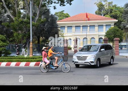 Un giovane vietnamita e una donna che indossa un cappello di riso su una bicicletta elettrica a da Nang, Vietnam, Asia Foto Stock