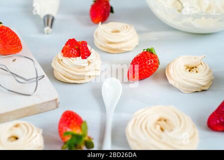 Fragola PavlovaHomemade piccola fragola pavlova meringa torte alla crema dessert con menta fresca Foto Stock