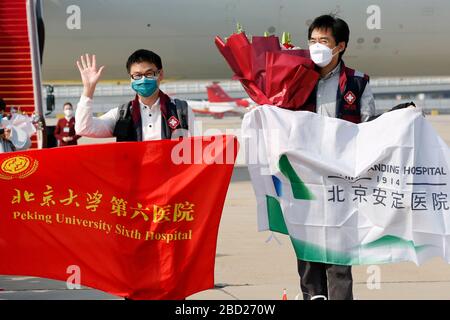 (200406) -- PECHINO, 6 aprile 2020 (Xinhua) -- i membri della squadra medica nazionale posano per una foto dopo essere arrivati all'aeroporto internazionale di Pechino capitale, capitale della Cina, 6 aprile 2020. Un team medico nazionale di 557 medici è tornato a Pechino lunedì dopo aver accompagnato la provincia di Hubei nella lotta contro il COVID-19. (Xinhua/Zhang Yuwei) Foto Stock