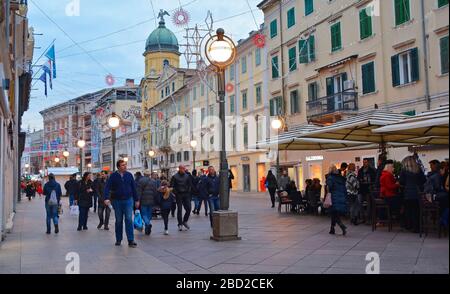 Rijeka, Croazia - 24 dicembre 2019. La gente del posto e i visitatori acquistano e bevono in una bancarella di Natale su Korzo, la strada principale per lo shopping nel centro Foto Stock