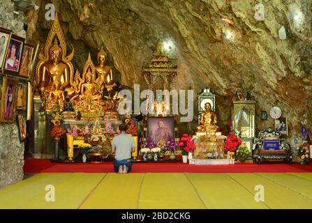 Uomo che prega nella grotta tempio buddista Wat Tham Pha Plong. Chiang Dao, Provincia di Chiang mai, Thailandia. Foto Stock
