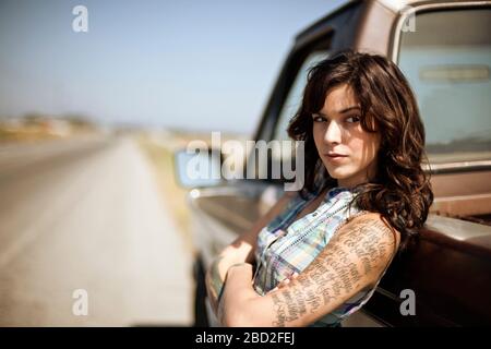 Donna che si appoggia contro il suo camion abbattuta pick-up. Foto Stock