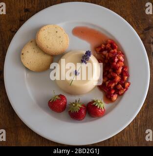 Panna cotta a base di crema locale, servita con fragole coltivate su isola, preparata dallo chef Piers Lewin su St Agnes, Isole di Scilly Foto Stock