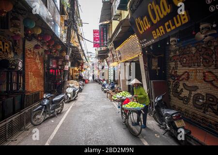 Un venditore di fiori vende fiori dalla sua bicicletta per le strade di Hanoi, Vietnam. Foto Stock