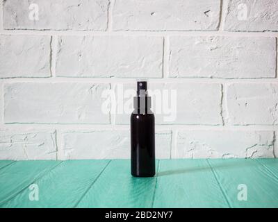 black bottle with sunscreen, antiseptic, sunscreen, empty bottle against a brick wall Foto Stock