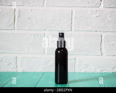 black bottle with sunscreen, antiseptic, sunscreen, empty bottle against a brick wall Foto Stock