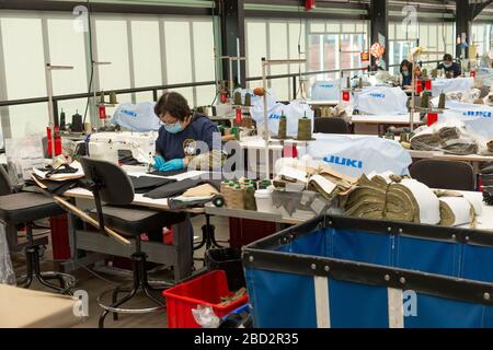 New York, NY - 6 aprile 2020: I lavoratori lavorano sulla linea di produzione gestita da Crye Precision per produrre attrezzature protettive per gli operatori sanitari a Brooklyn Navy Yard Foto Stock