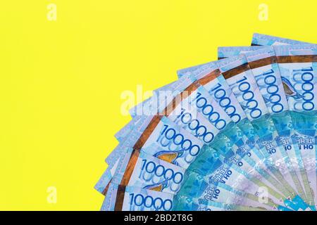 Le fatture di spargimento di tinge denominate a diecimila. Sfondo giallo. Foto Stock