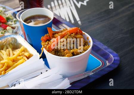 Vassoio con cibo da strada. Plov, cibo tradizionale dell'Asia centrale. Street food e cucina all'aperto concetto Foto Stock