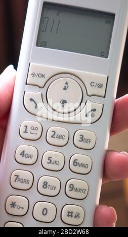 Telefono cordless in mano. Numero di emergenza 911 Foto Stock