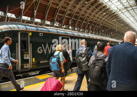LONDRA, INGHILTERRA - LUGLIO 2018: Persone che camminano lungo una piattaforma alla Stazione di Londra Paddington per salire a bordo di un treno dopo che il numero della piattaforma è stato annunciato. Foto Stock