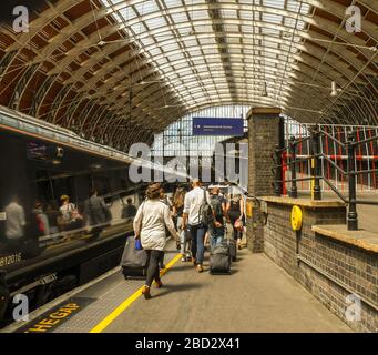 LONDRA, INGHILTERRA - LUGLIO 2018: Persone che camminano lungo una piattaforma alla stazione di Londra Paddington per salire a bordo di un treno Foto Stock