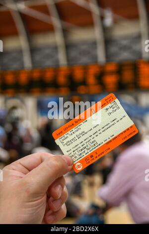 LONDRA, INGHILTERRA - LUGLIO 2018: Vista ravvicinata di un biglietto ferroviario alla Stazione di Paddington di Londra, con le informazioni sulle partenze sullo sfondo. Foto Stock