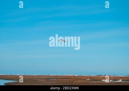 L'aereo vola verso l'aeroporto sul fiume nella città di Faro in Portogallo. Molte barche in una giornata di sole sul fiume. Foto Stock