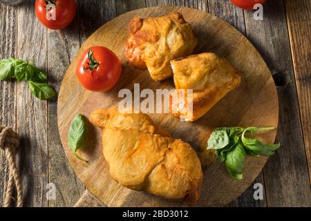 Calzone di Panzerotti, casereccia italiana, con basilico e salsa Foto Stock