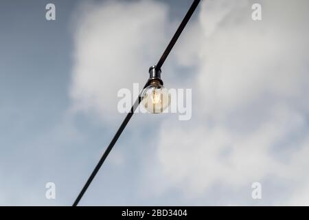 Lampada isolata appesa con cielo sullo sfondo. Foto Stock