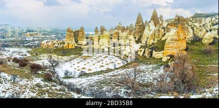 Le terre agricole collinari, coperte di neve sulla linea di alte rocce di fiaba camino, Cappadocia, Turchia Foto Stock