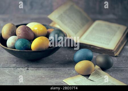 Pasqua. Uova colorate naturalmente con libro d'annata Foto Stock